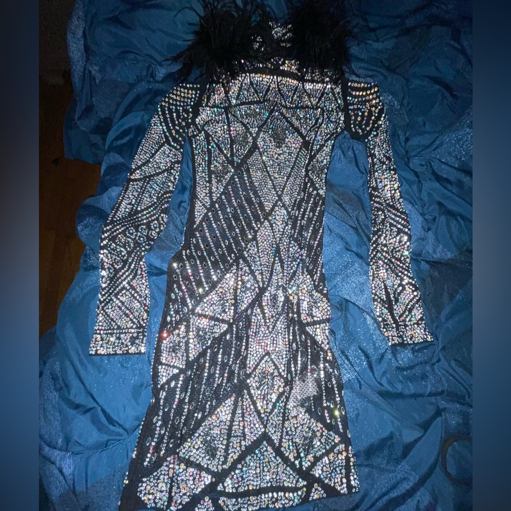Black Party dress covered in rhinestones and stops at about knee length.